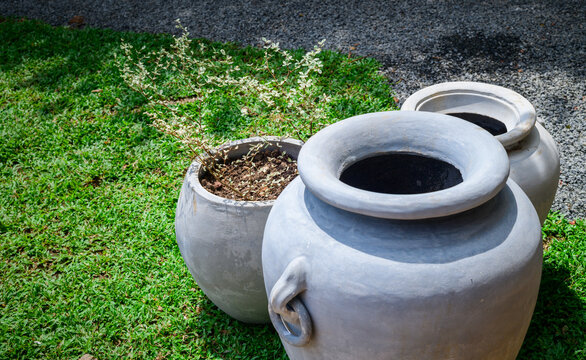 Cement garden pots with a planter on a lush green lawn