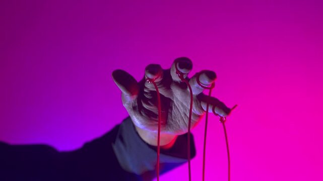 Hand with Puppet Strings in Neon Pink Light &mdash; Control and Manipulation Concept
