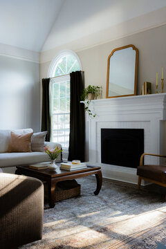 Sunlit Living Room with White Fireplace and Vaulted Ceiling