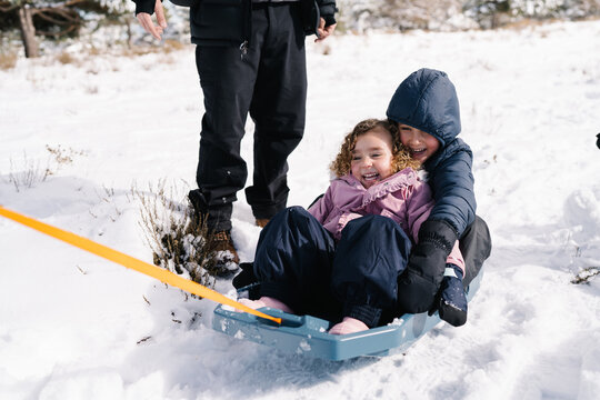 Happy children sledding enjoying winter snow activity