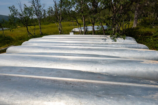 Grovelsjon, Sweden, A row of aluminum canoes on a beach front on Lake Grovelsjon.