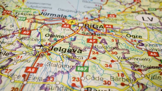 riga, latvia road network leading to the capital, gliding over atlas map