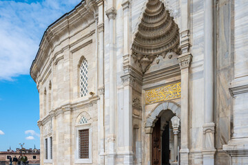 Obraz premium The grand marble entrance gate and facade of the historic Nuruosmaniye Mosque in Istanbul, Turkey. Magnificent Ottoman Baroque architecture details under a blue sky