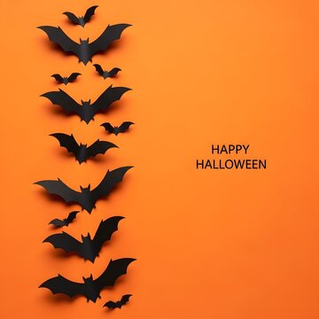 Vertical row of black paper bats flying on bright orange background with happy halloween text for holiday greeting card Happy Halloween