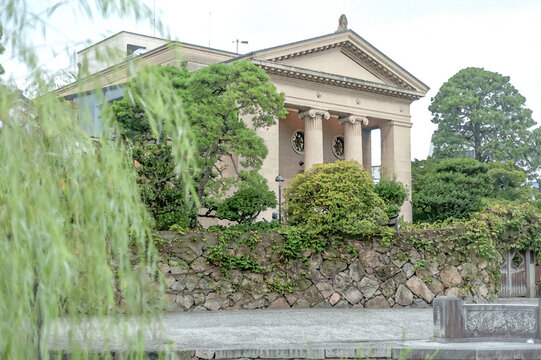 大原美術館の本館を彩る重厚なイオニア式の柱と美しい新緑の木々/The Main Building of the Ohara Museum of Art Adorned with Dignified Ionic Columns and Beautiful Fresh Green Trees