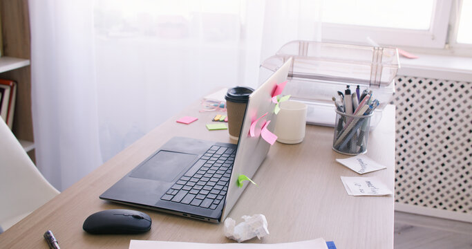 Business office. Productive workspace. Organized desk with laptop planning organizational sticky notes supporting task management.