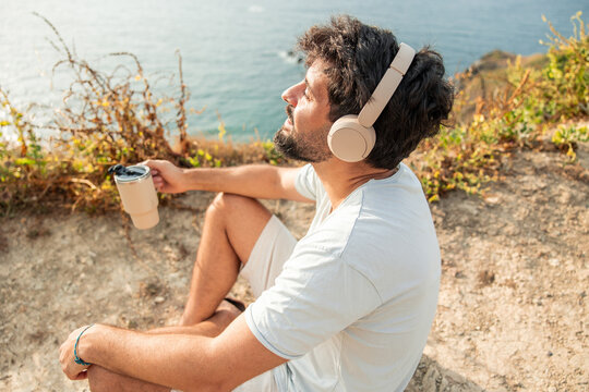 Man enjoying digital detox listening music by the ocean