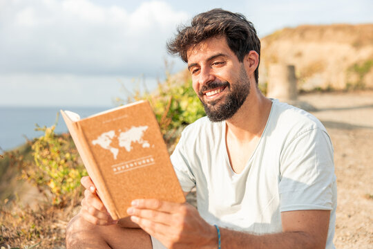 Man relaxing after remote work reading adventure book