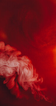 Dye spread. Pigment splash. Orange red paint flow haze explosion art abstract sparkling background. Shiny twirl blend color blur fluid.