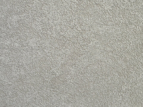 Fine stucco wall texture background. Grey beige decorative cement plaster with bark beetle effect. Clean modern building facade backdrop.