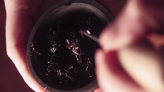 Vertical video. Shisha tobacco bowl. Ritual preparing. Unrecognizable man hands blending fruit using metallic tool making mix in cafe workplace.