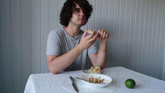 Enjoying a meal with guacamole and lime at a table indoors