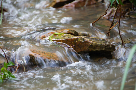 Water streams down the rocky mountain terrain after the rain