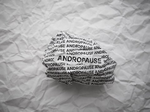 Crumpled paper ball with words Andropause on a crumpled white paper background