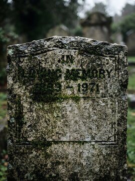 Ancient weathered gravestone with moss in cemetery closeup gravestone cemetery tombstone memorial weathered religion mourning gravemarker heritage sculpture