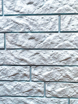 High resolution close-up of a white decorative stone brick wall with realistic rough texture and horizontal masonry pattern. Ideal seamless background for architecture, interior design, construction a