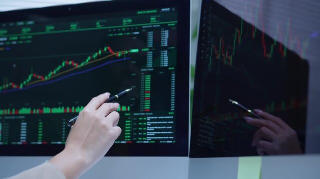 Financial analyst monitoring stock market data on multiple computer screens showing cryptocurrency and forex charts