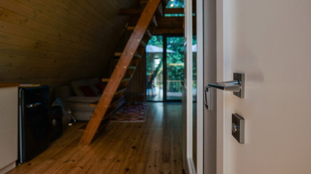 Modern cabin interior with wooden stairs and a view of the outdoors