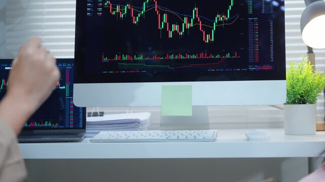 Financial analysts discussing cryptocurrency stock market chart on a computer screen in the office during a bull market
