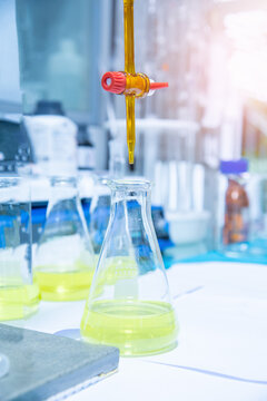 Burette filled with yellow liquid in laboratory.