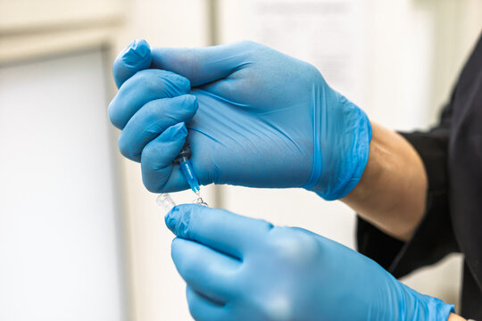 Syringe drawing medication from vial for injection