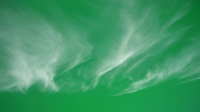 Thin cirrus clouds flowing over green screen backdrop. High-resolution sky texture for seamless digital compositing and VFX.