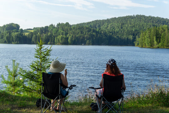 Women relaxing by Glomma river in Norway enjoying nature