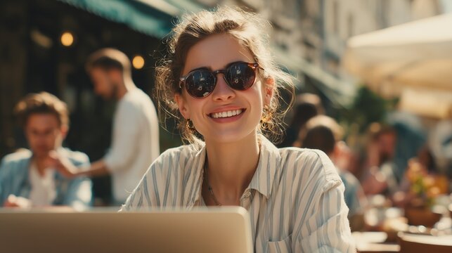 Young woman working on laptop at outdoor cafe
