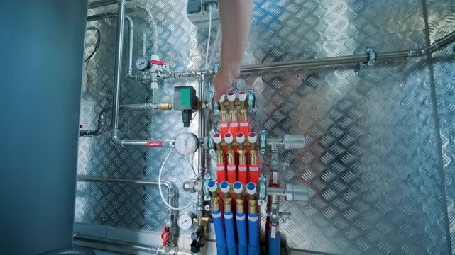 Close-up of a complex underfloor heating distribution manifold with PEX pipes and pressure gauges in a modern boiler room