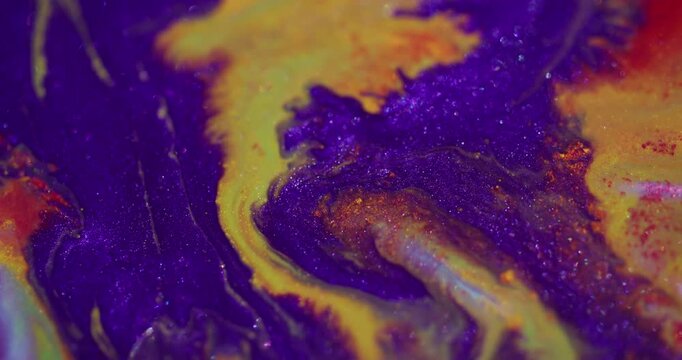 Ink flow. Blur glitter texture. Neon purple color dye blending in yellow red orange sparkling art fluid with wavy abstract background.