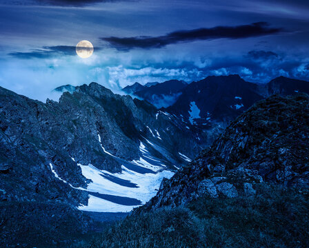 romania mountain landscape in summer at night. full moon over travel background of alpine scenery in fagaras mountain ridge. european summer outdoor adventures. mysterious fantasy