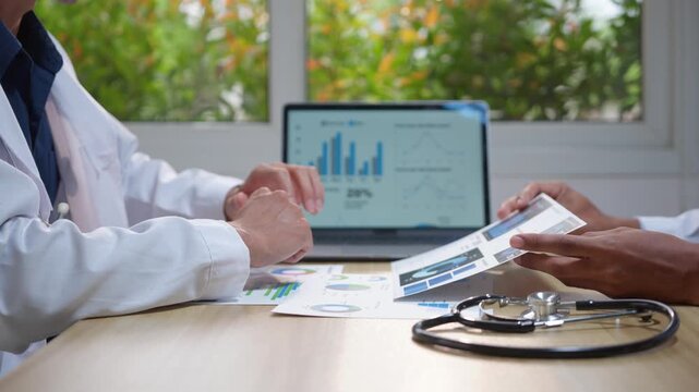 Doctors discussing medical data and statistics during a team meeting in a hospital conference room