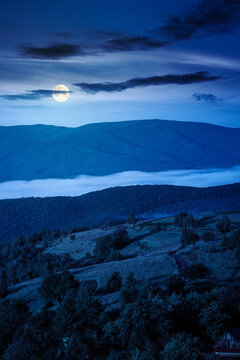 carpathian mountain landscape on a foggy night. outdoor adventure with stunning view. full moon over mountainous countryside of ukraine in summer. mysterious rolling hills