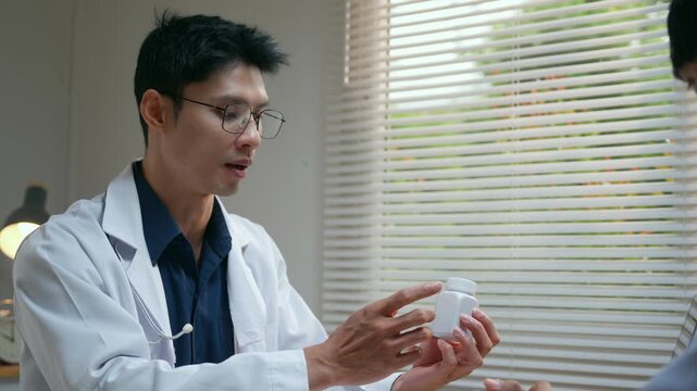Asian doctor explaining prescription medication dosage to a patient during a medical consultation in a hospital clinic office