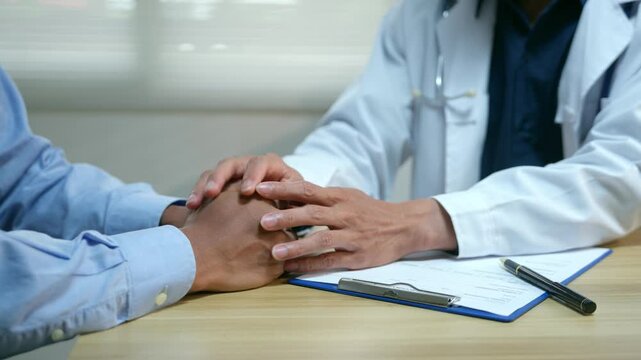 Compassionate doctor comforting an anxious patient and holding hands showing empathy and support in the clinic