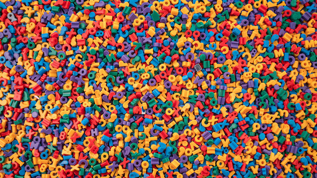 Colorful plastic alphabet letters scattered densely a vibrant educational background toys learning