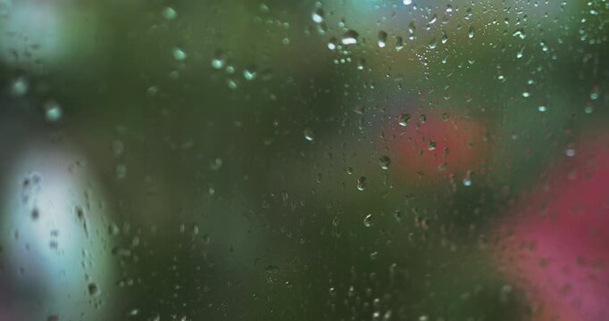 Macro shot of heavy raindrops running down window pane