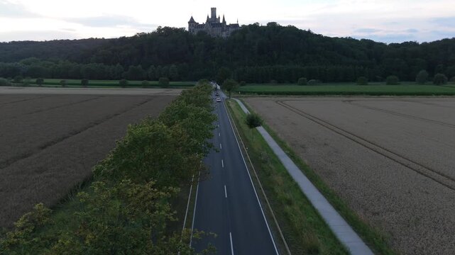 Country road leading toward Marienburg Castle through farm fields