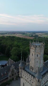 Vertical video drone closing up the Marienburg Castle tower above the forest