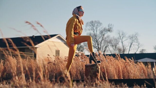 Futuristic Woman in Industrial Landscape Wearing Cyberpunk Fashion