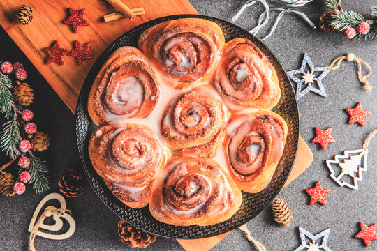 Cinnamon Rolls brioches or cinnamon rolls with icing sugar and cream cheese - decorated for Christmas