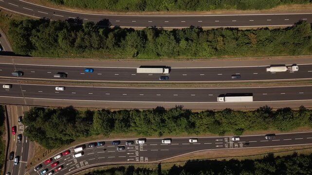Static top-down aerial drone footage of traffic flowing along the M4 motorway near Cardiff, Wales. Cars, vans and heavy goods vehicles travel through one of South Wales&rsquo; busiest transport corridors