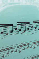 Fototapeta premium Musical Notes on Glass Window with Urban Street Reflection