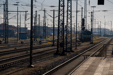 Munich railway tracks with metal overhead power lines, train platform and passenger locomotive engine under bright daylight in Germany © Алексей Горовой