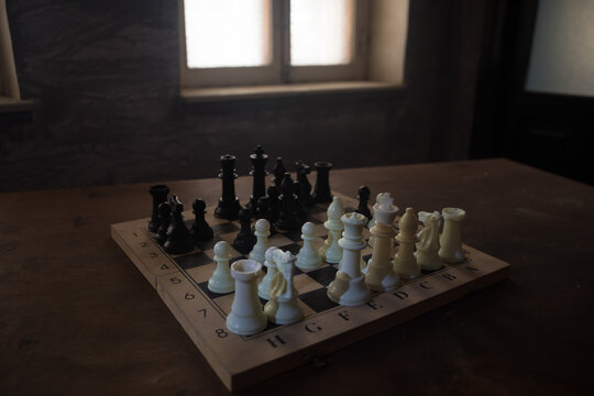 Chess board game concept of business ideas and competition and strategy ideas concep. Chess figures on a dark background with smoke and fog. Selective focus