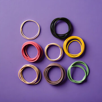 Colorful rubber bands flat lay on purple background