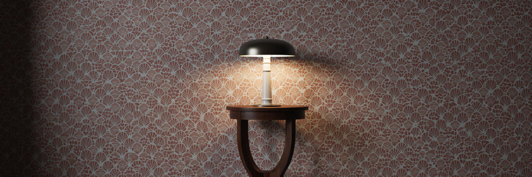 Table lamp with a dark shade sits on a wooden side table against a patterned wall