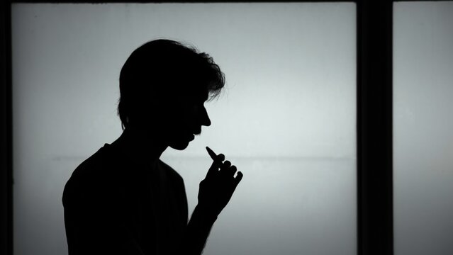 College Student Takes Silent Vape Pause. Silhouette Of Individual Releasing Vapor During Study Session . Media