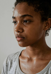 Obraz premium Young african american woman with sweat on her face and neck after intense physical activity or workout