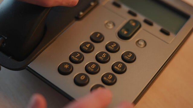 Focused Shot Of Finger Pressing Numbered Buttons On Office Telephone Keypad In Professional Environment . Media